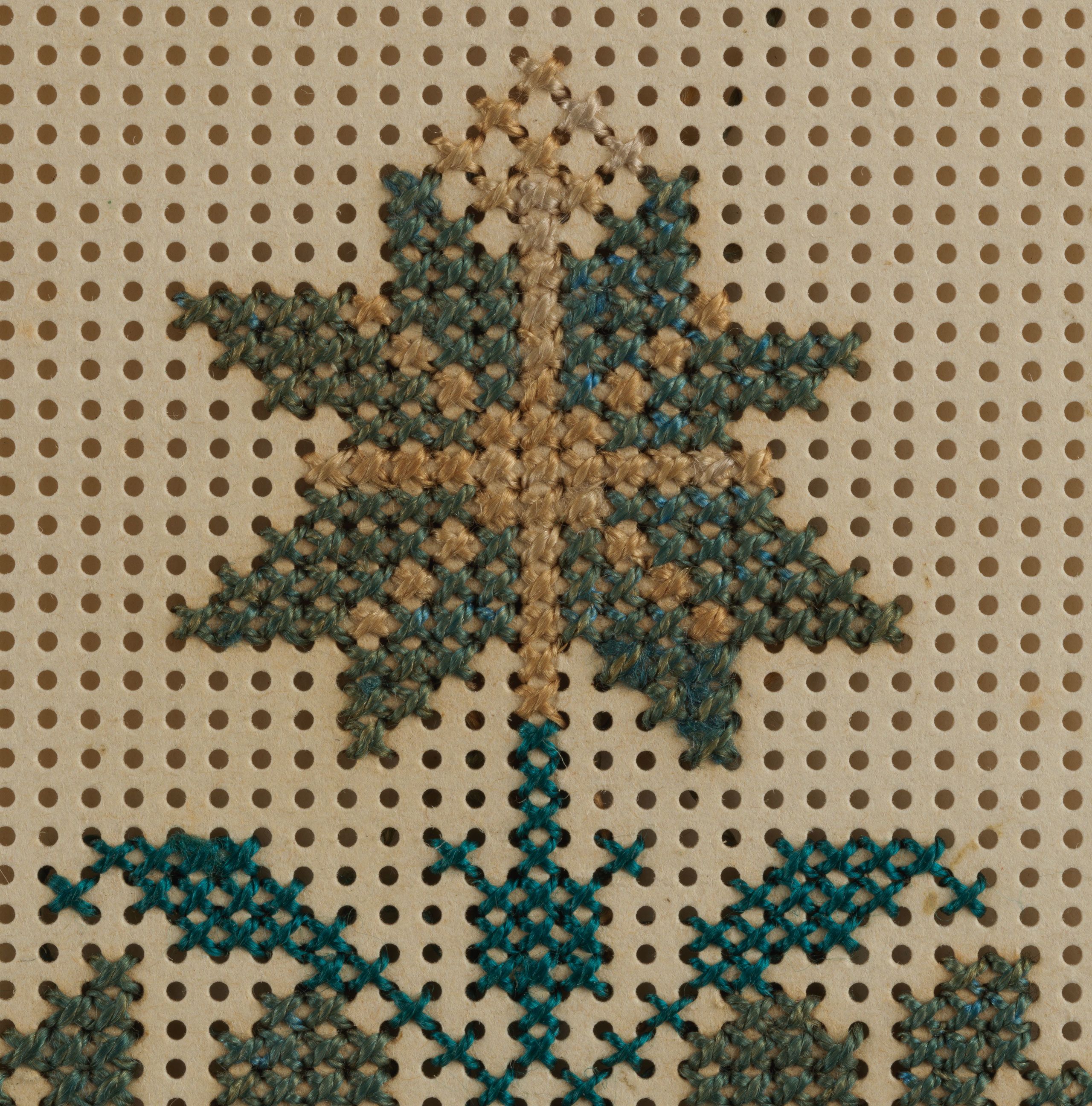 Detail of the flower and leaves in the embroidery sampler.