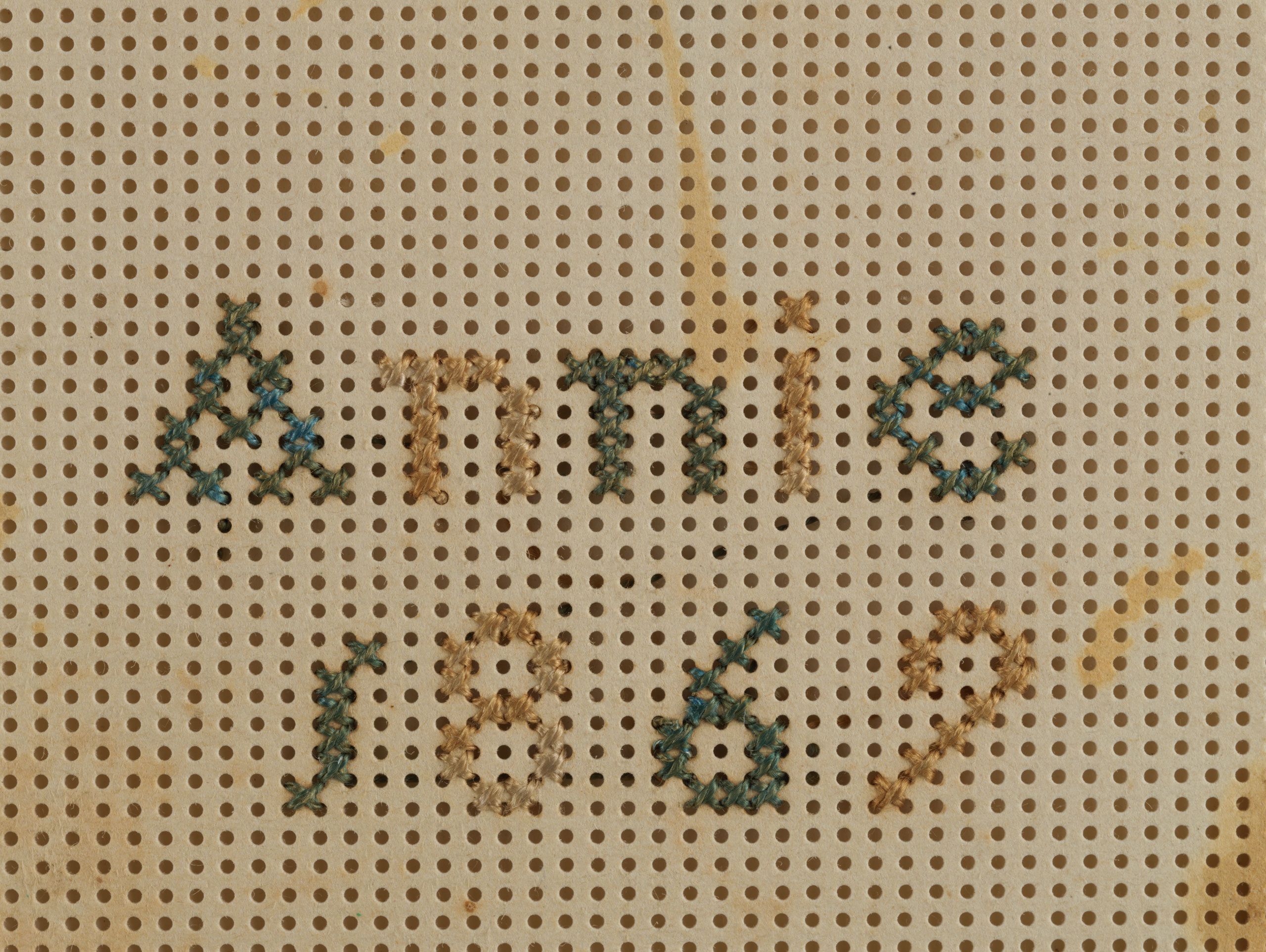 Detail of embroidery sampler, showing the perforated cardboard used to make the sampler.