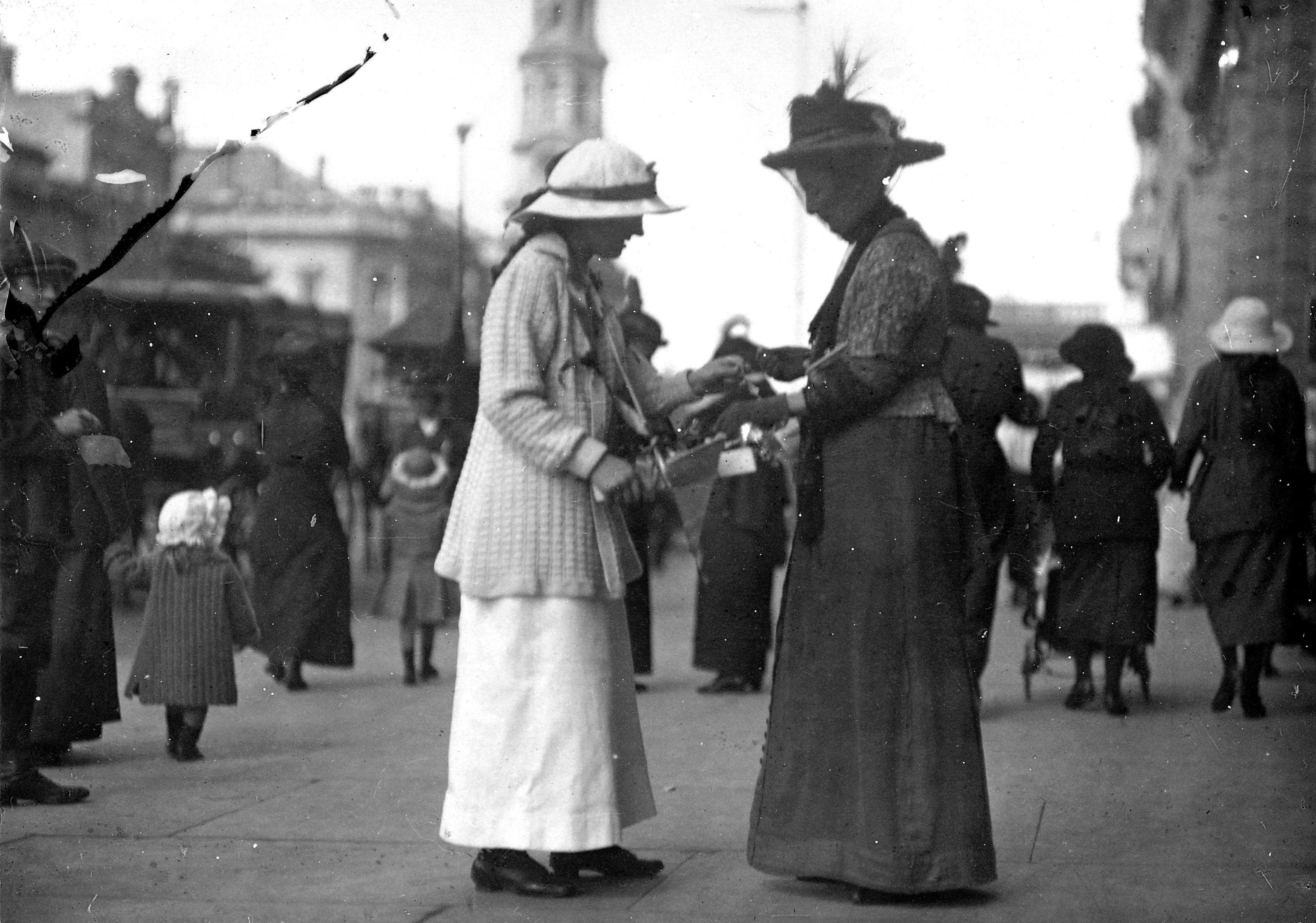 A woman charity collector selling a badge to a passer-by in King William Street, Adelaide, South Australia. SLSA: PRG 280/1/17/738