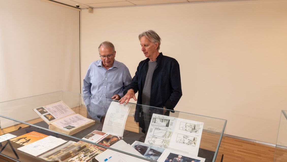 Former State Library Director Geoff Strempel and Scott Hicks viewing the display of his personal film memorabilia collection.