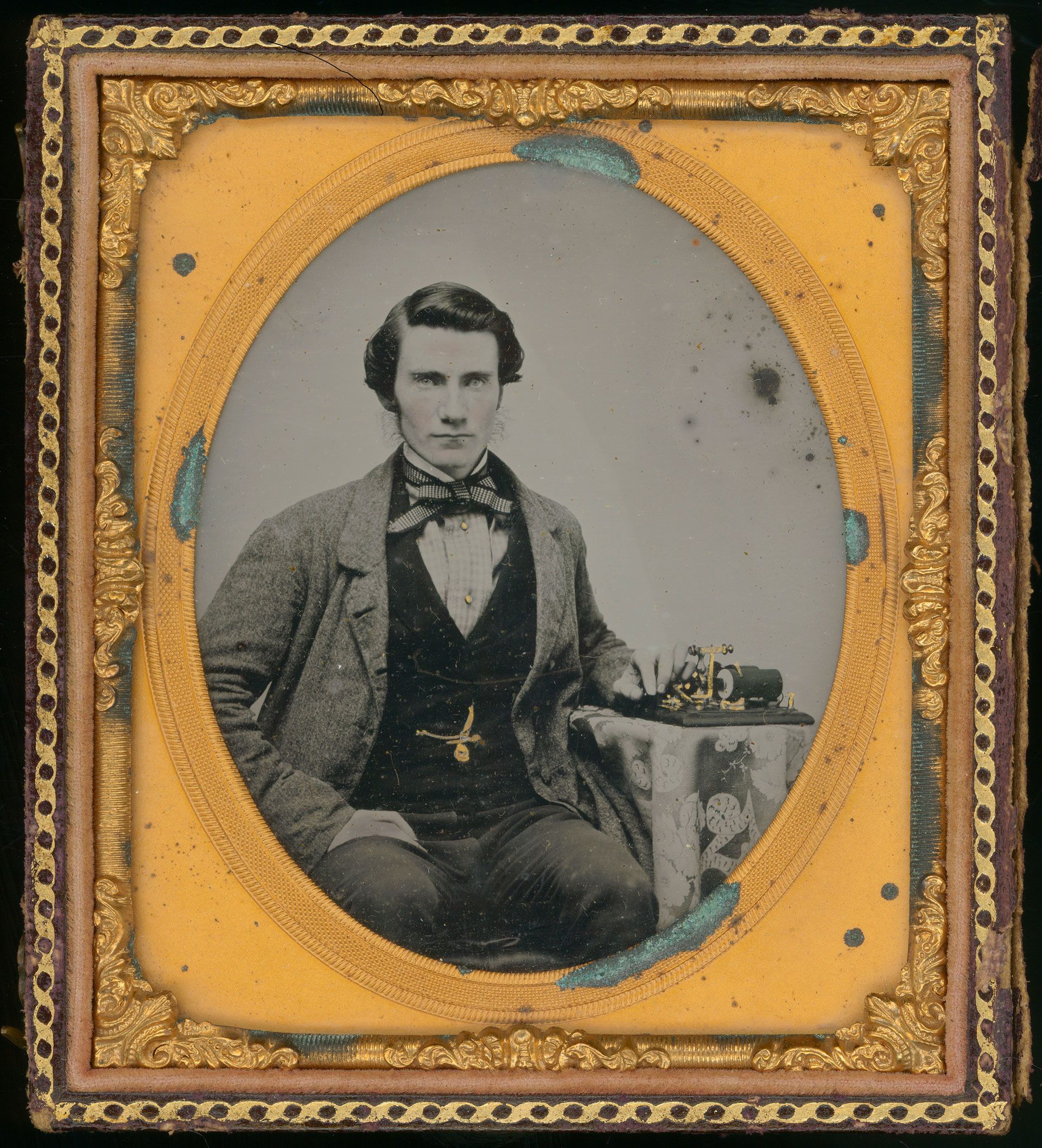 A stately ambrotype portrait of a young James Stapleton sitting with his telegraph device. James is aged 21 when this portrait was done in 1855. SLSA: B 19711/1