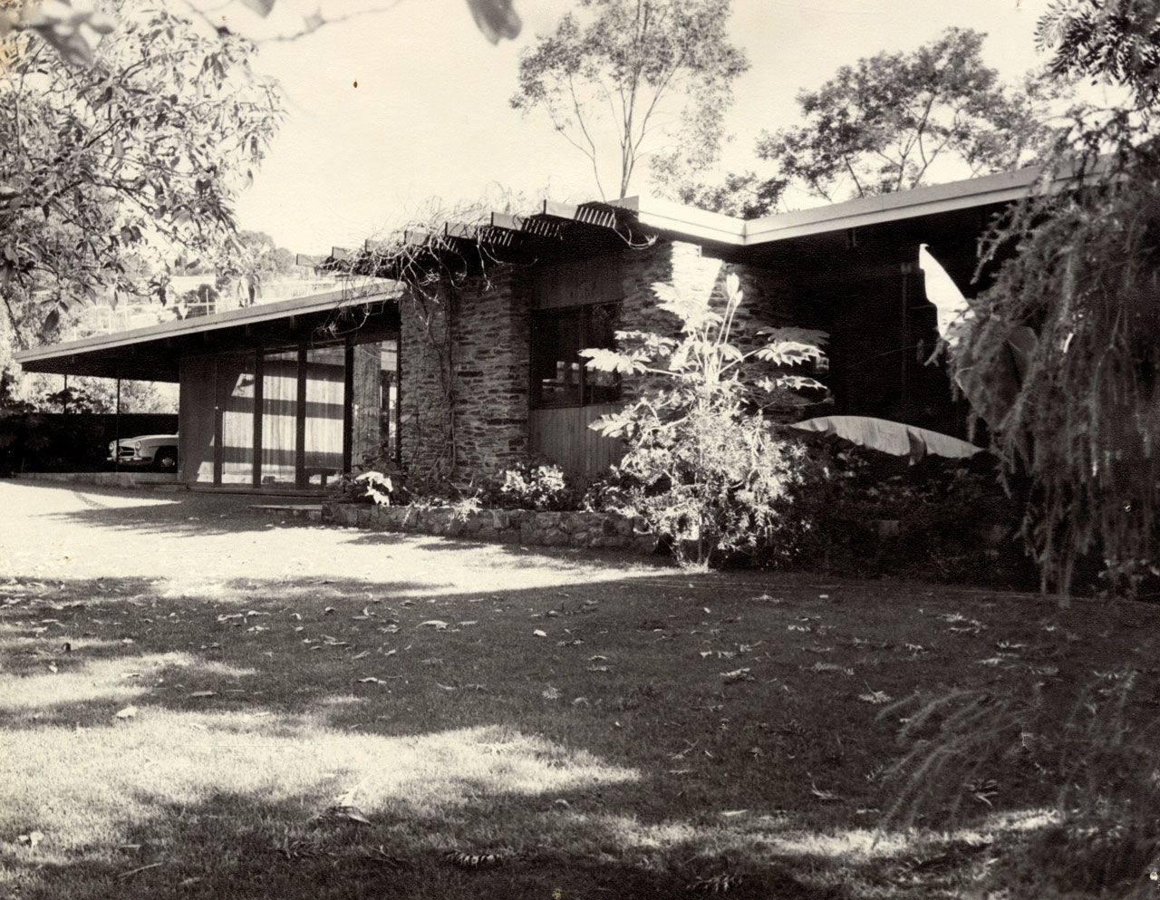 One of a series of miscellaneous photographs of South Australian residential buildings, most likely designed by South Australian architects. Front view of a flat roofed house with large windows and a feature stone façade section. Circa 1965-72 SLSA: BRG 346/34/1/133