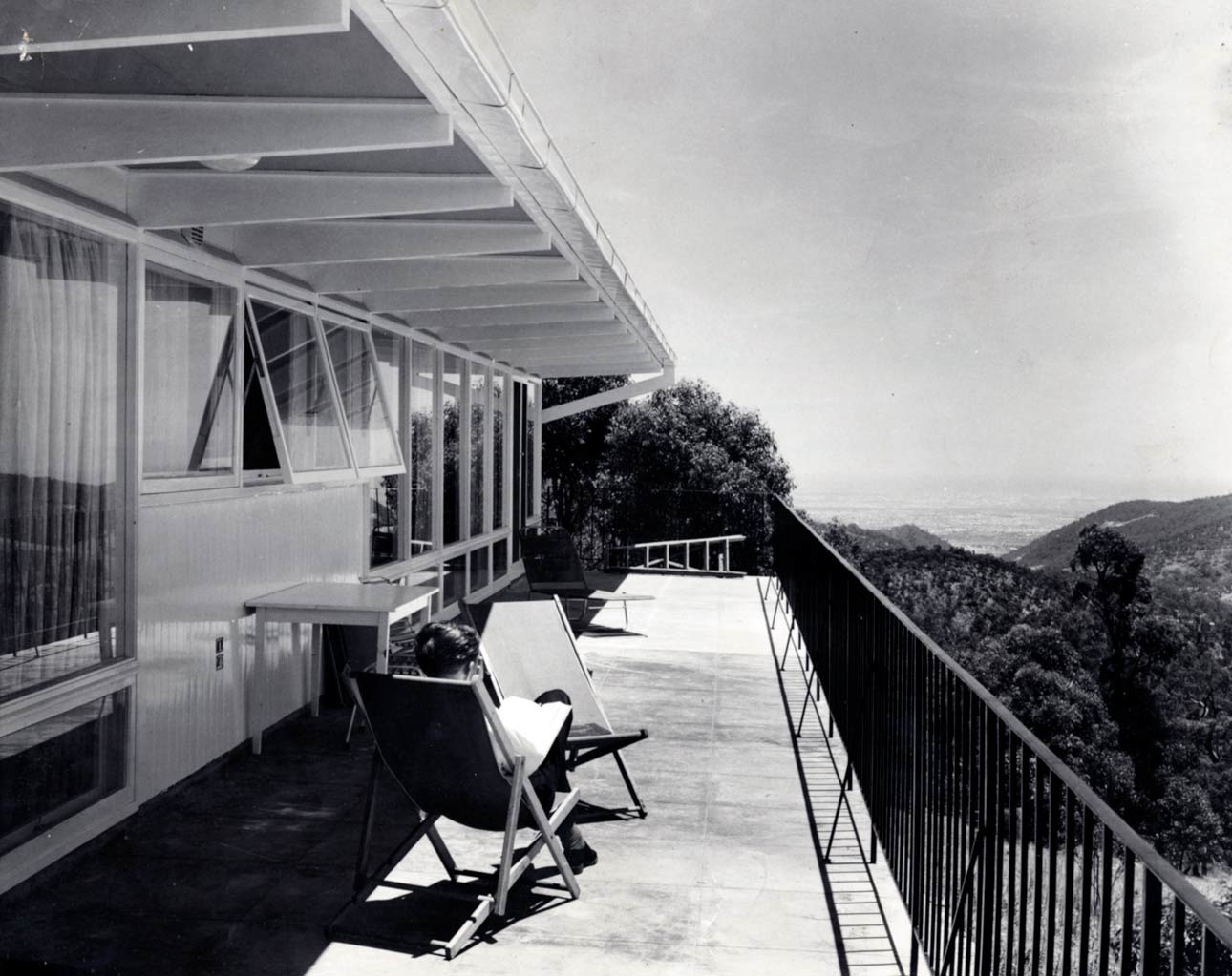 Enjoying the view from the front balcony overlooking the hills and Adelaide, circa 1961. This photograph features the house on a hill at Montacute designed by John S. Chappel Pty Ltd, architect, for Robert Clark.  SLSA: BRG 346/29/46/4
