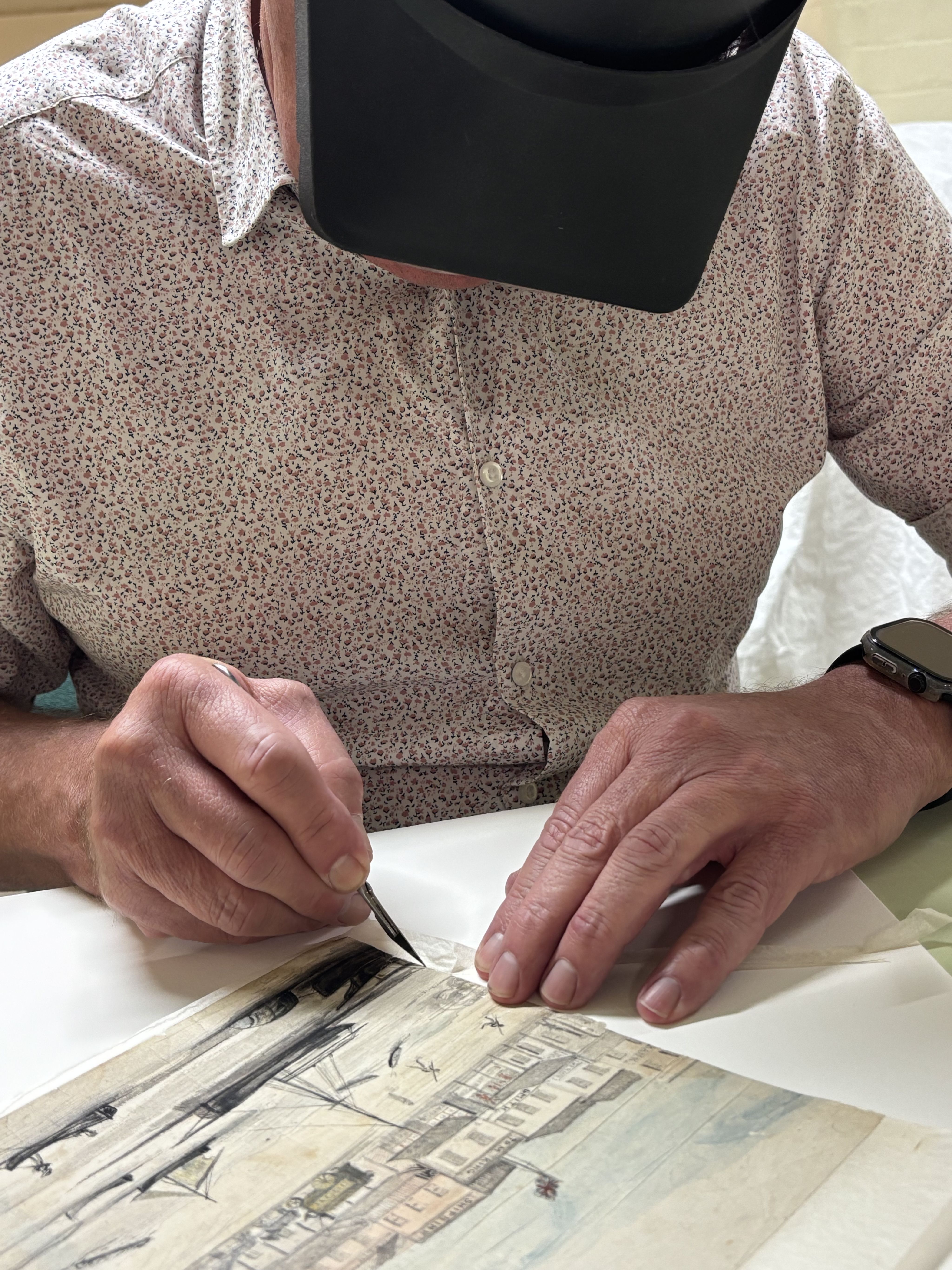 Senior Conservator, Peter Zajicek, separates the individual pages in order to correctly align the image.