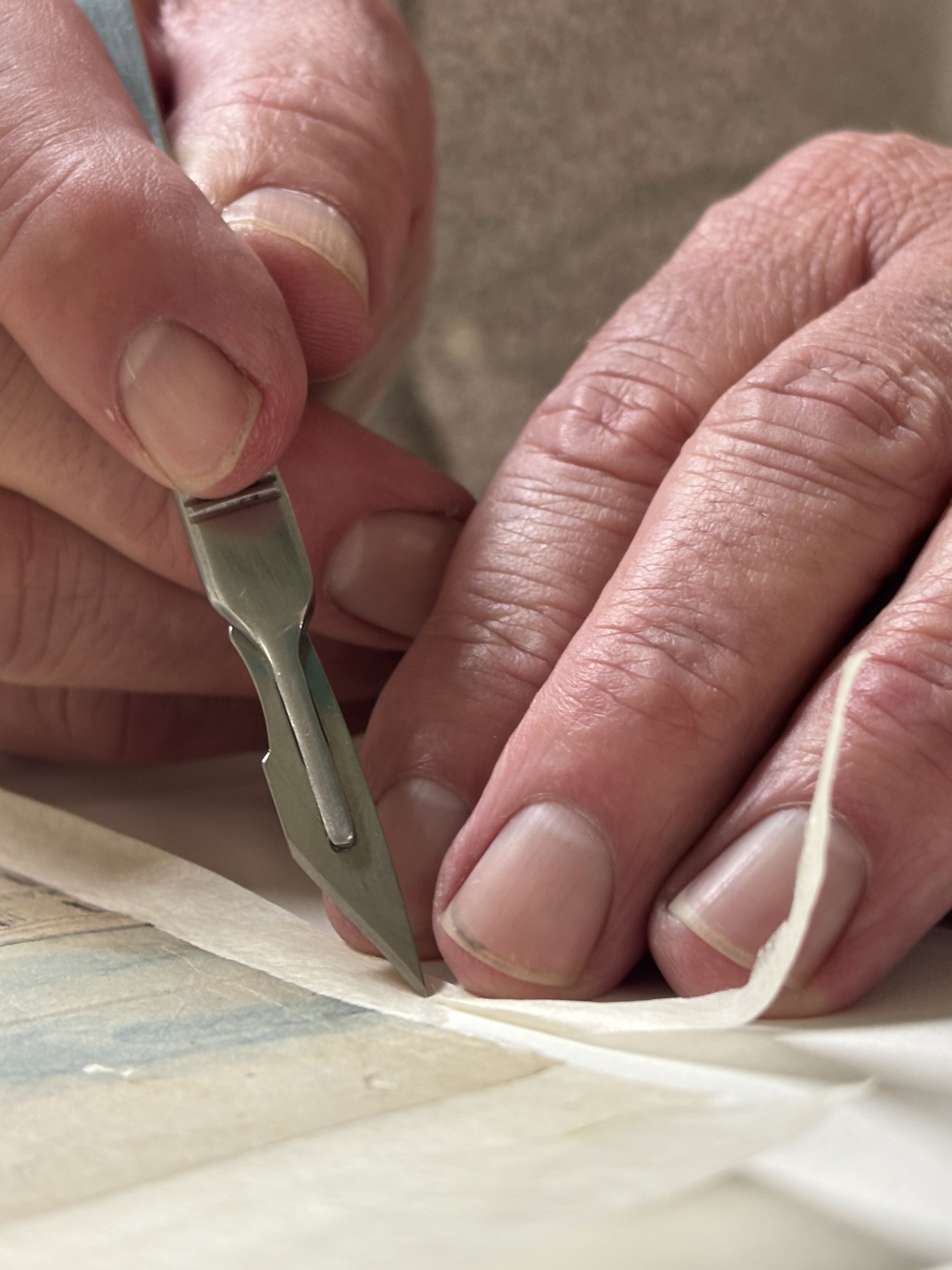 Senior Conservator, Peter Zajicek, separates the individual pages in order to correctly align the image.