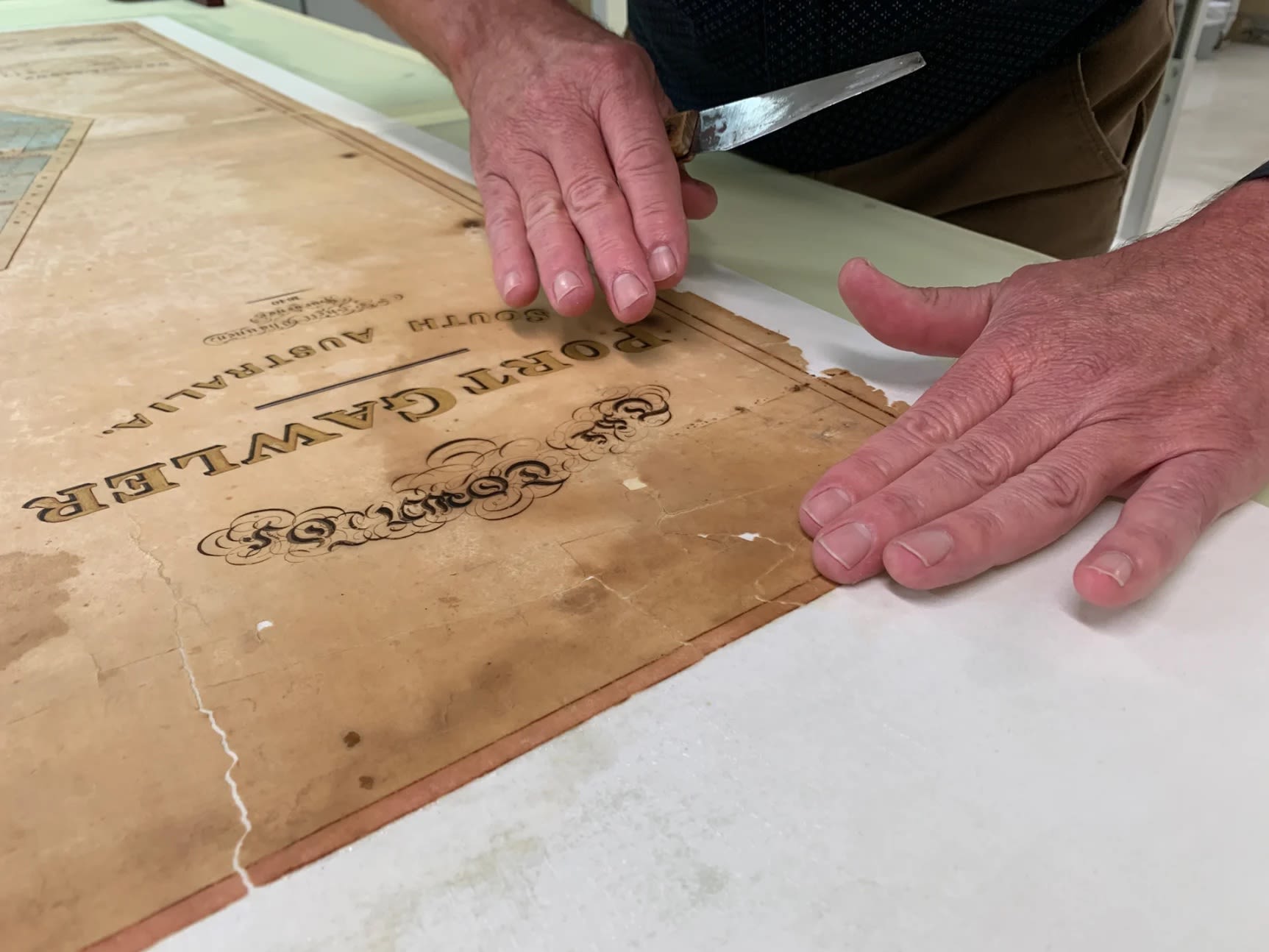 Peter aligning the pieces of the Port Gawler map. Photograph SLSA: February 2023
